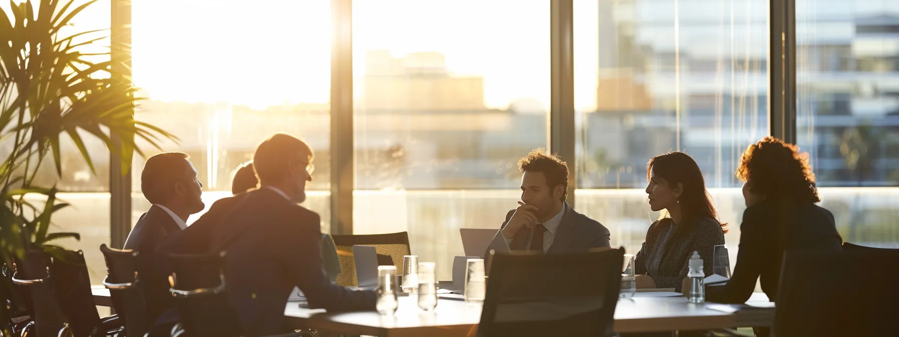 a group of business professionals engaged in a focused discussion around a conference table.