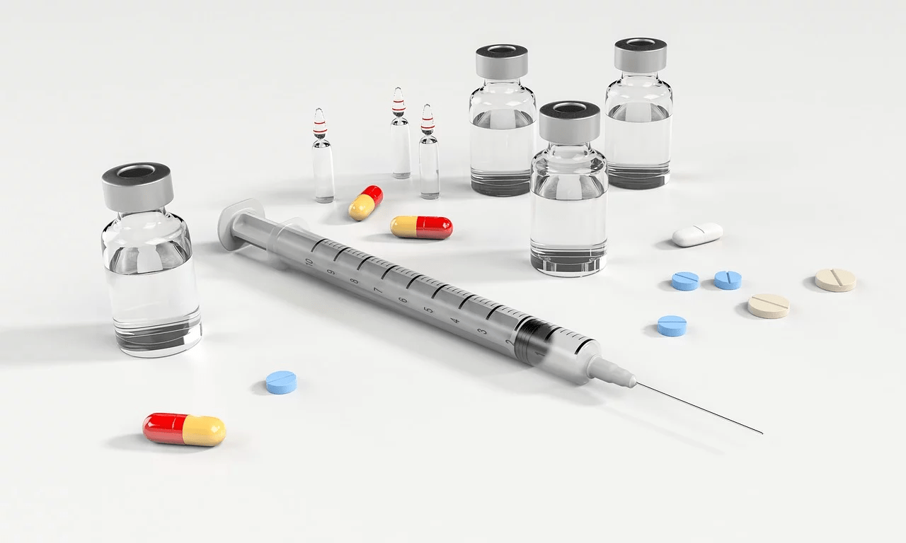 a syringe with liquid and pills